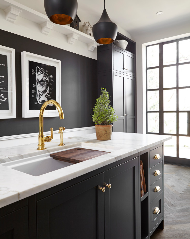 Enclosed kitchen - mid-sized transitional single-wall medium tone wood floor and brown floor enclosed kitchen idea in Toronto with an undermount sink, shaker cabinets, black cabinets, marble countertops, white backsplash, subway tile backsplash, stainless steel appliances, an island and white countertops
