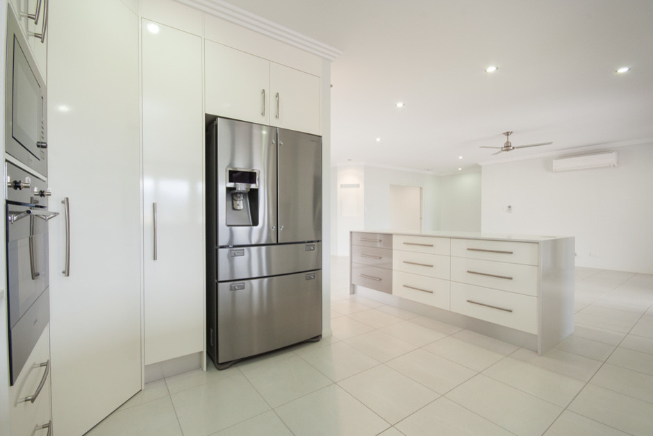 Inspiration for a large modern u-shaped separate kitchen in Cairns with a drop-in sink, white cabinets, granite benchtops, metallic splashback, glass sheet splashback, stainless steel appliances, ceramic floors and with island.