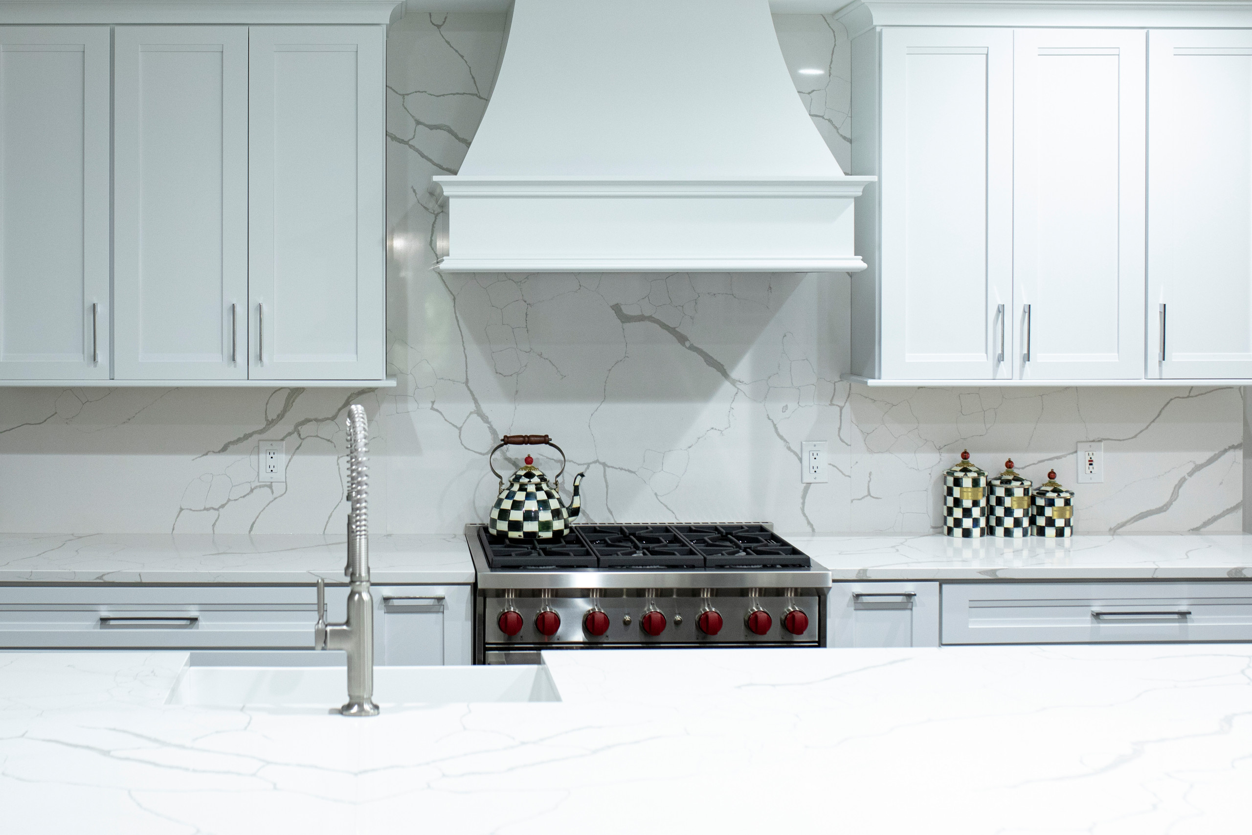 Example of a large transitional u-shaped dark wood floor and brown floor eat-in kitchen design in Detroit with an undermount sink, shaker cabinets, white cabinets, quartz countertops, white backsplash
