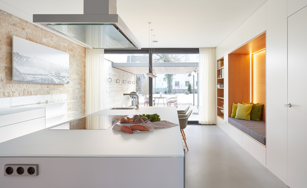 Large contemporary galley eat-in kitchen in Stuttgart with an integrated sink, flat-panel cabinets, white cabinets, glass benchtops, beige splashback, stone slab splashback, vinyl floors, with island, grey floor and white benchtop.