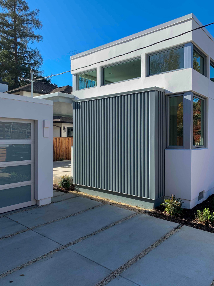 Photo of a grey house exterior in San Francisco with metal siding, a flat roof and a white roof.