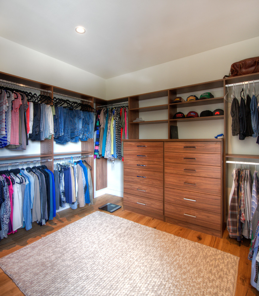 Design ideas for a contemporary gender-neutral walk-in wardrobe in San Diego with flat-panel cabinets, medium wood cabinets, medium hardwood floors and orange floor.