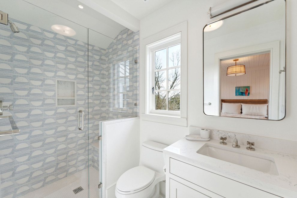 Historic Sea Cabins - Fun kid's bathroom featuring matte black built-in medicine cabinet mirror, blue and white patterned tile, custom inset cabinetry and quartz countertops.