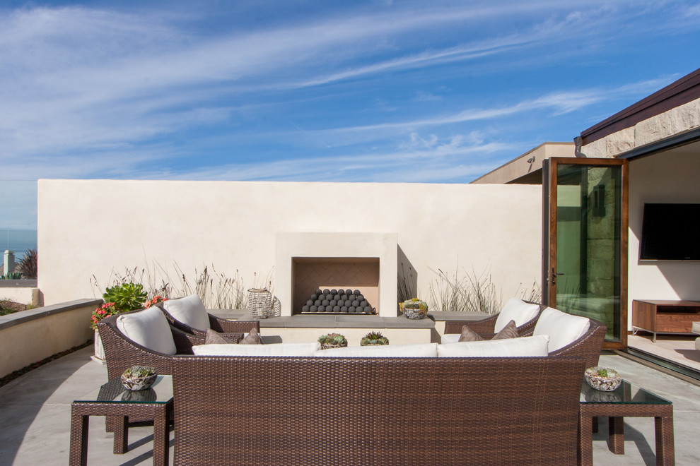 This is an example of a modern backyard patio in Orange County with a fire feature.