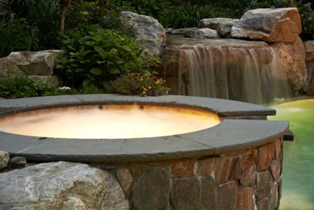 Inspiration for a mid-sized transitional backyard stone and custom-shaped natural hot tub remodel in Boston