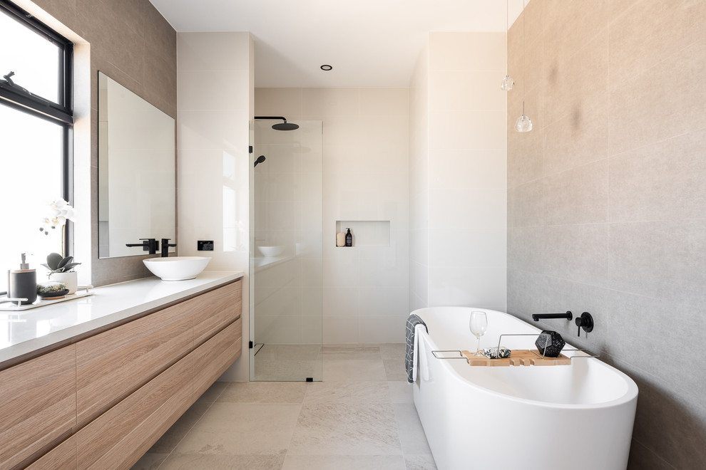 This is an example of a scandinavian bathroom in Perth with flat-panel cabinets, light wood cabinets, a freestanding tub, a curbless shower, beige tile, white tile, cement tile, beige walls, a vessel sink, beige floor, an open shower and white benchtops.