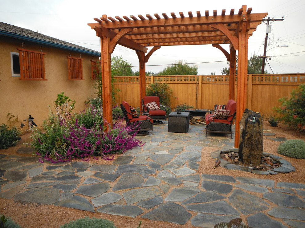 Inspiration for a large arts and crafts backyard patio in San Diego with a pergola, a water feature and gravel.