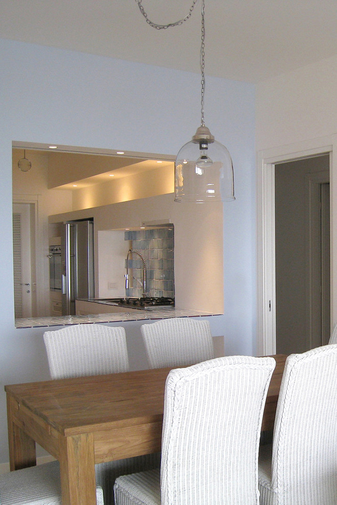 Photo of a mid-sized beach style dining room in Other with multi-coloured walls, ceramic floors and beige floor.