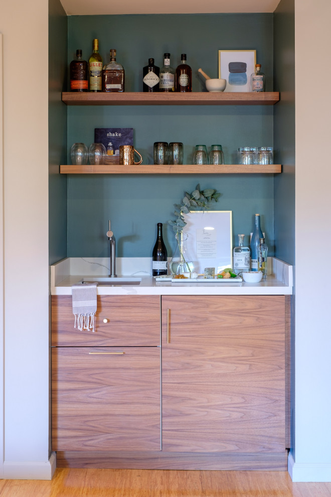 Inspiration for a contemporary single-wall wet bar in San Francisco with an undermount sink, flat-panel cabinets, medium wood cabinets, blue splashback, medium hardwood floors, brown floor and white benchtop.