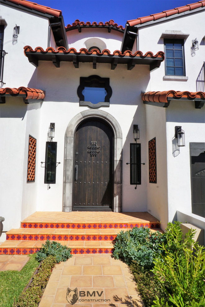 Großes, Zweistöckiges Einfamilienhaus mit Putzfassade, weißer Fassadenfarbe, Satteldach, Ziegeldach und rotem Dach in Los Angeles