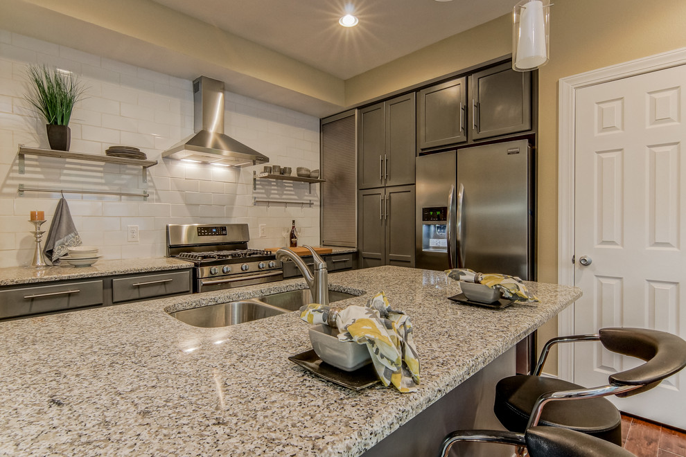 Mid-sized contemporary l-shaped eat-in kitchen in Austin with a double-bowl sink, shaker cabinets, grey cabinets, granite benchtops, yellow splashback, ceramic splashback, stainless steel appliances and no island.