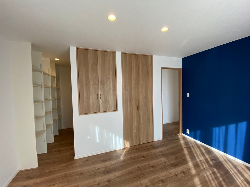 Foto di un soggiorno di medie dimensioni con pareti blu, pavimento in compensato, nessun camino, nessuna TV, pavimento marrone, soffitto in carta da parati e carta da parati