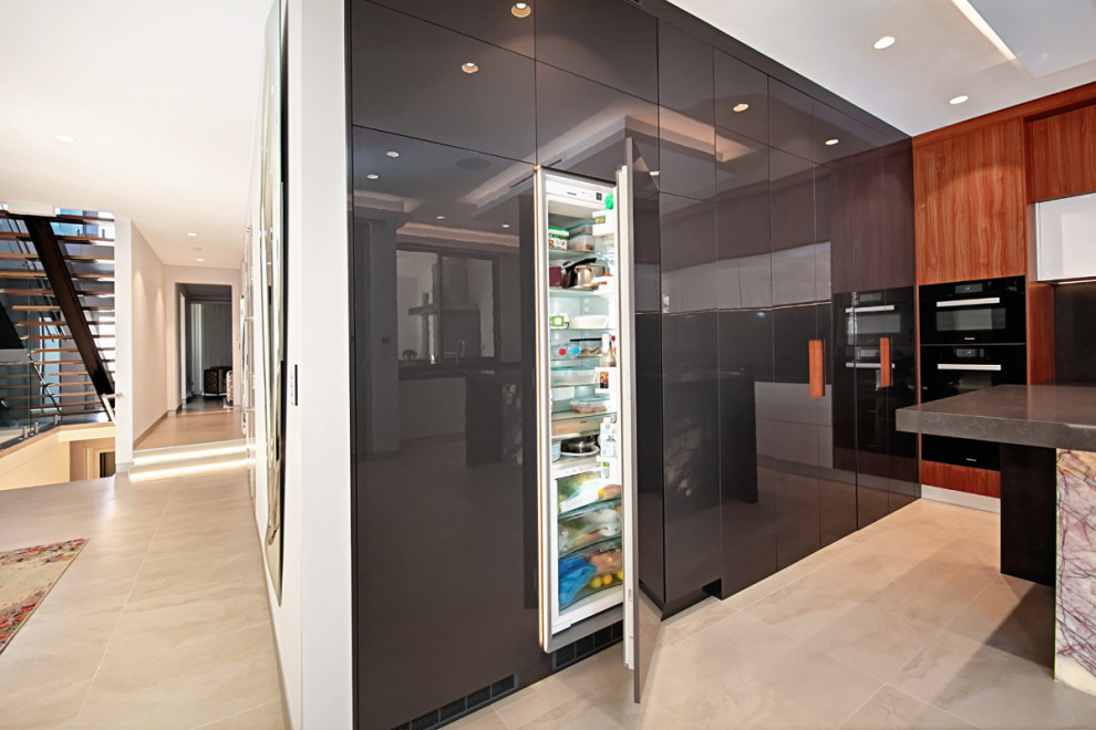 This is an example of a mid-sized modern u-shaped open plan kitchen in Sydney with a double-bowl sink, recessed-panel cabinets, dark wood cabinets, marble benchtops, black splashback, marble splashback, black appliances, ceramic floors, with island, beige floor, black benchtop and coffered.