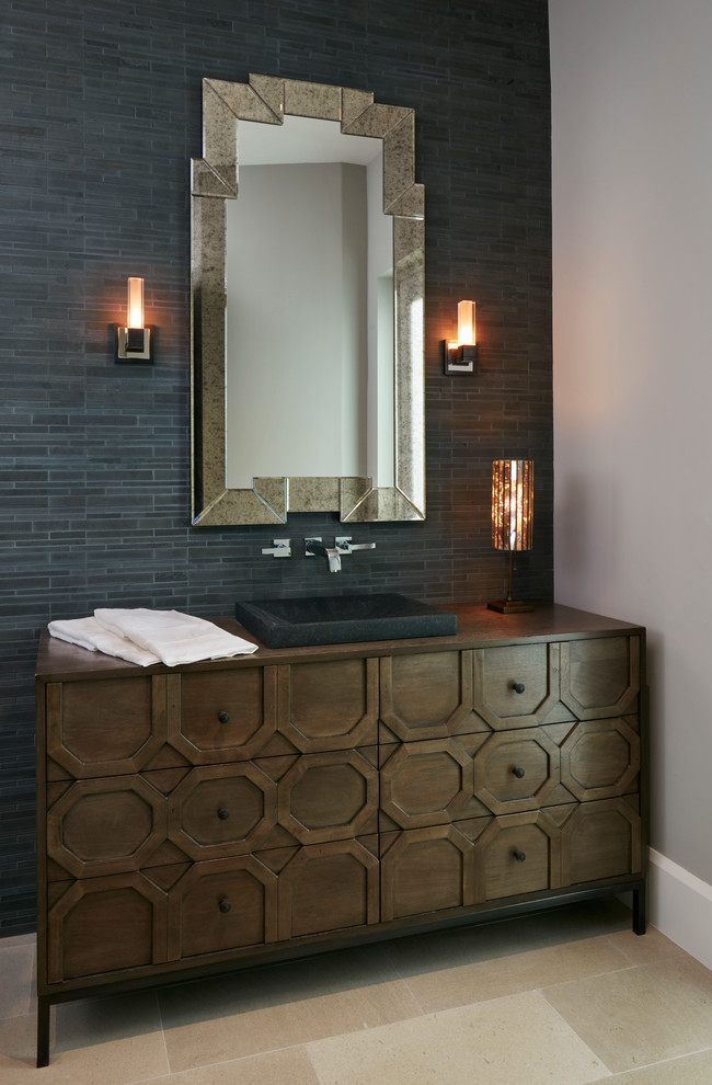 Transitional powder room in Miami with furniture-like cabinets, dark wood cabinets, grey walls, a vessel sink, gray tile and beige tile.