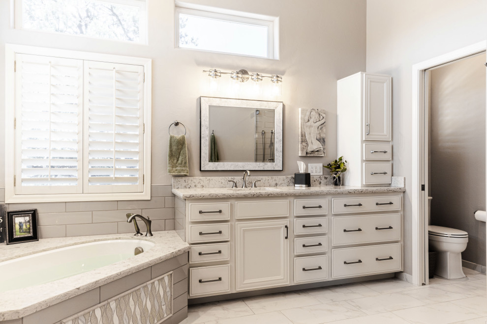Design ideas for a large country master bathroom in Phoenix with raised-panel cabinets, white cabinets, an alcove tub, an alcove shower, a two-piece toilet, gray tile, subway tile, grey walls, ceramic floors, an undermount sink, engineered quartz benchtops, white floor, a sliding shower screen, white benchtops, a double vanity and a built-in vanity.