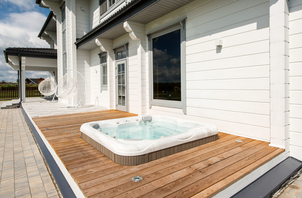 This is an example of a contemporary side yard pool with a hot tub and decking.