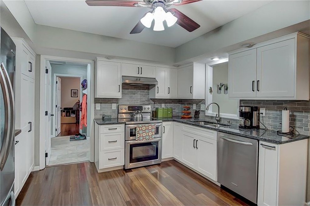 Transitional medium tone wood floor kitchen photo with shaker cabinets, white cabinets and granite countertops