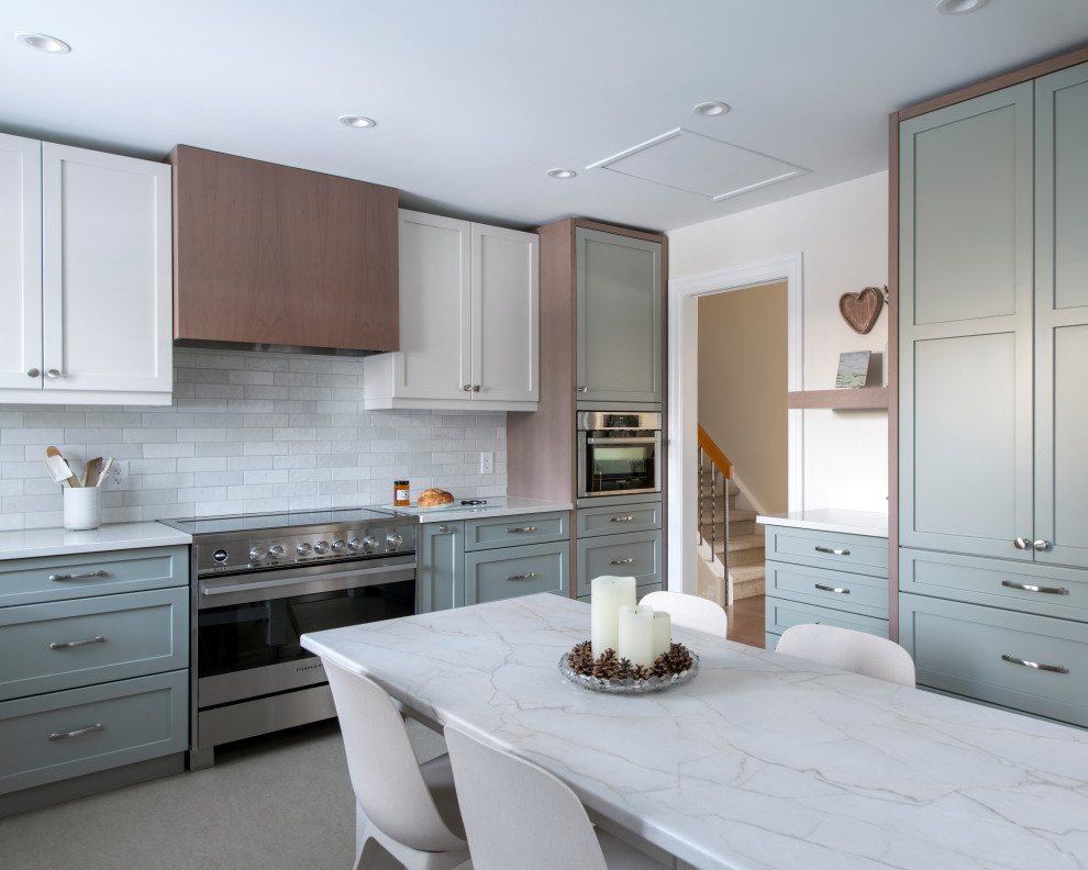 Mid-sized transitional u-shaped linoleum floor and gray floor eat-in kitchen photo in Ottawa with a farmhouse sink, shaker cabinets, gray cabinets, quartz countertops, white backsplash, subway tile backsplash, stainless steel appliances, an island and white countertops