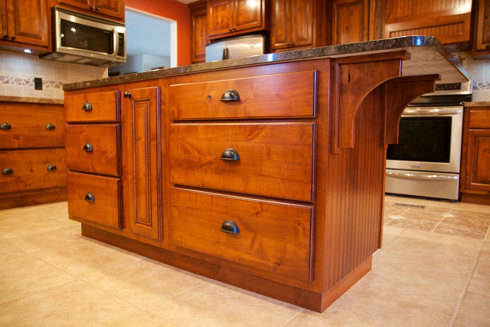 Kitchen - mid-sized kitchen idea with raised-panel cabinets, dark wood cabinets, granite countertops and an island