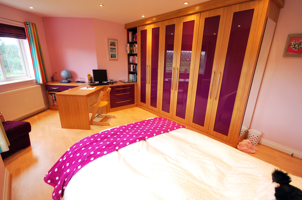 Inspiration for a mid-sized contemporary kids' room for girls in Manchester with pink walls and light hardwood floors.
