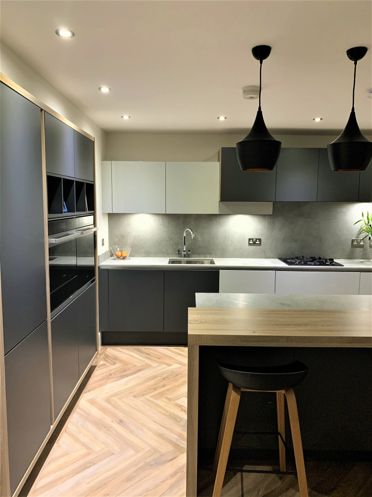 Design ideas for a small scandinavian l-shaped eat-in kitchen in Other with a double-bowl sink, flat-panel cabinets, light wood cabinets, concrete benchtops, black appliances, vinyl floors and with island.