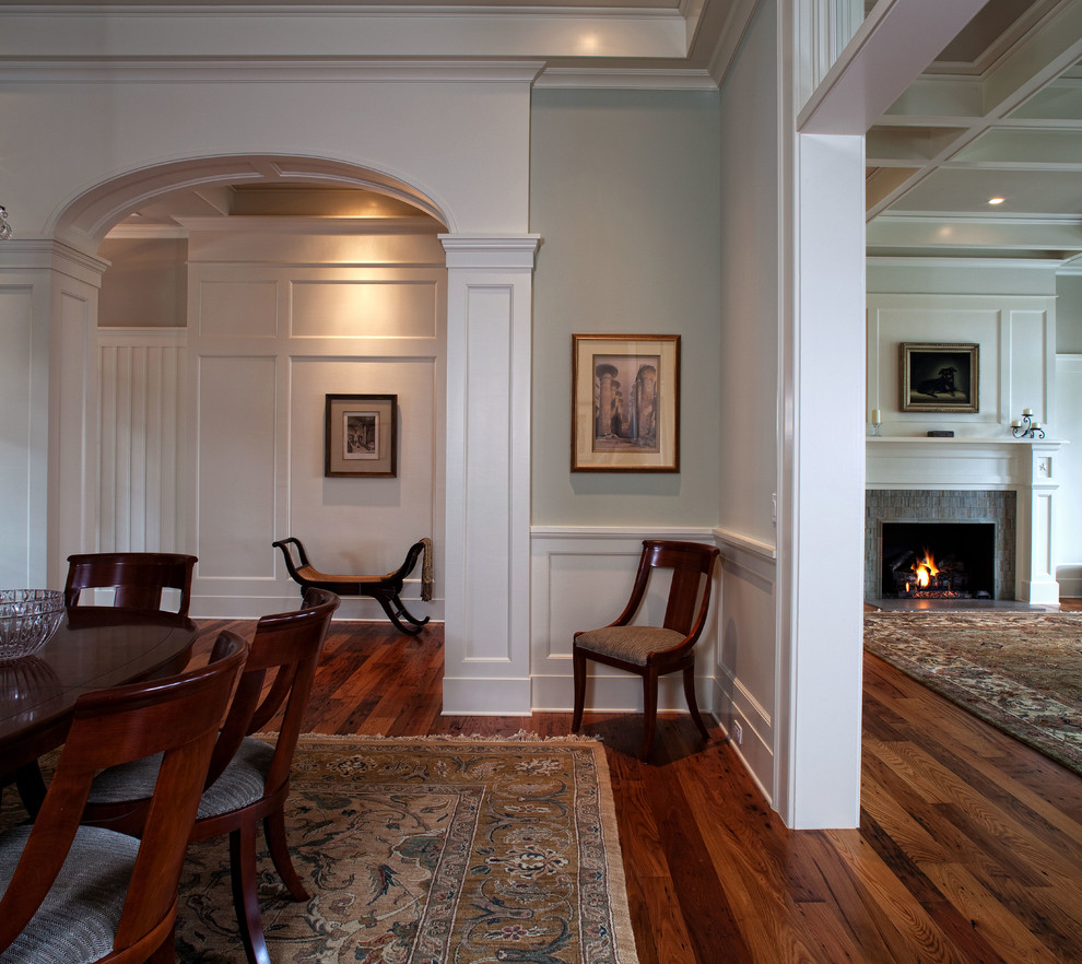 Mid-sized traditional dining room in Charleston with medium hardwood floors, a standard fireplace and a tile fireplace surround.
