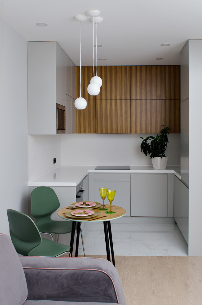 Small contemporary u-shaped open plan kitchen in Moscow with an undermount sink, flat-panel cabinets, grey cabinets, white splashback, white floor and white benchtop.