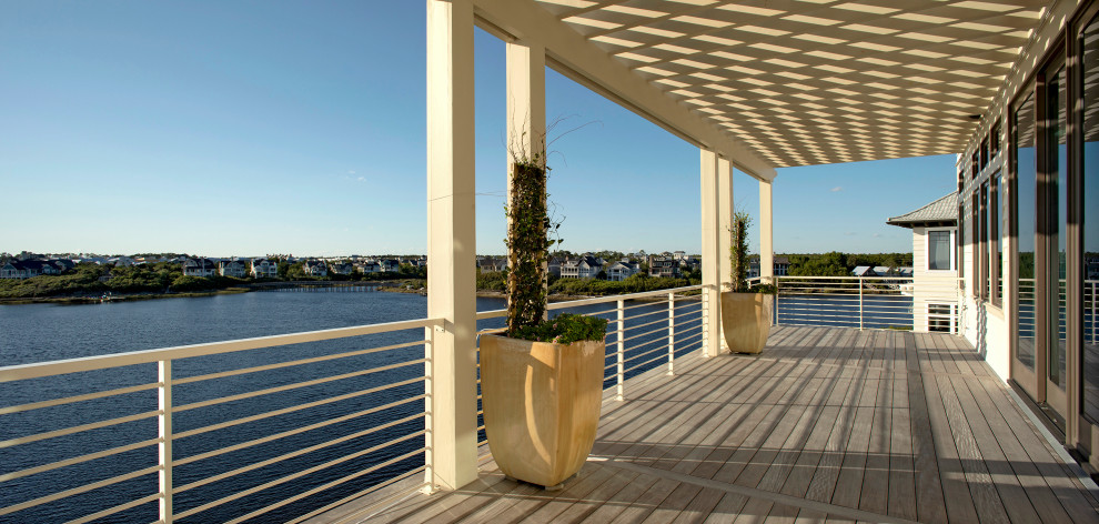 Inspiration for a large nautical back metal railing veranda in Other with with columns, decking and a pergola.