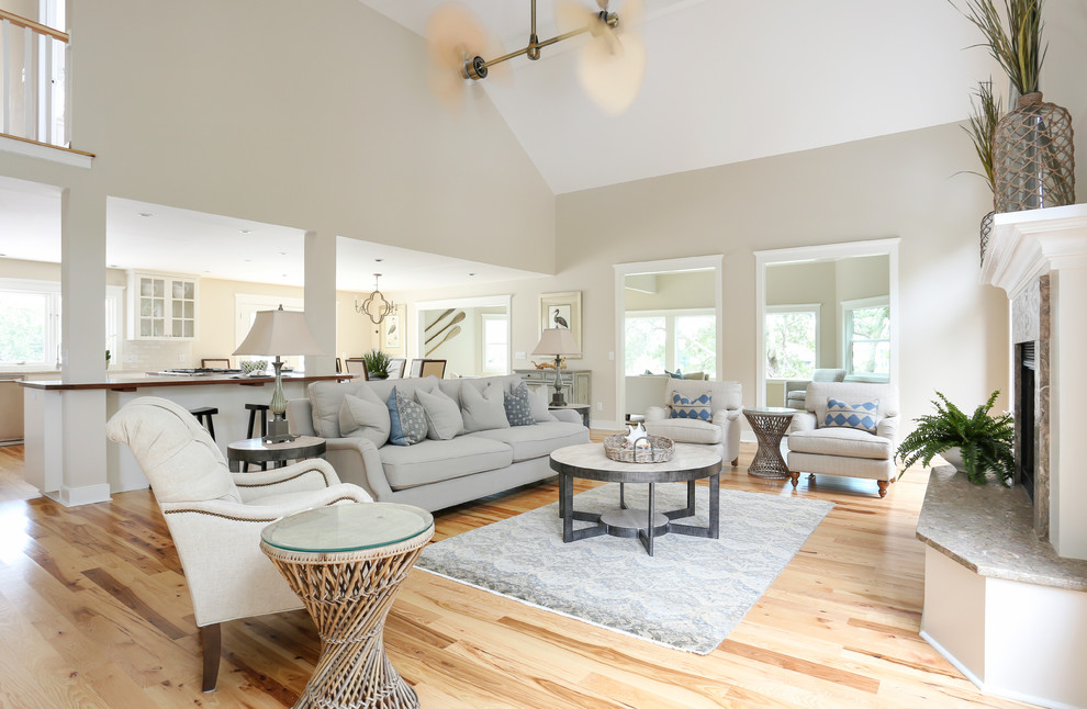 This is an example of a beach style formal open concept living room in San Francisco with grey walls, light hardwood floors and a standard fireplace.
