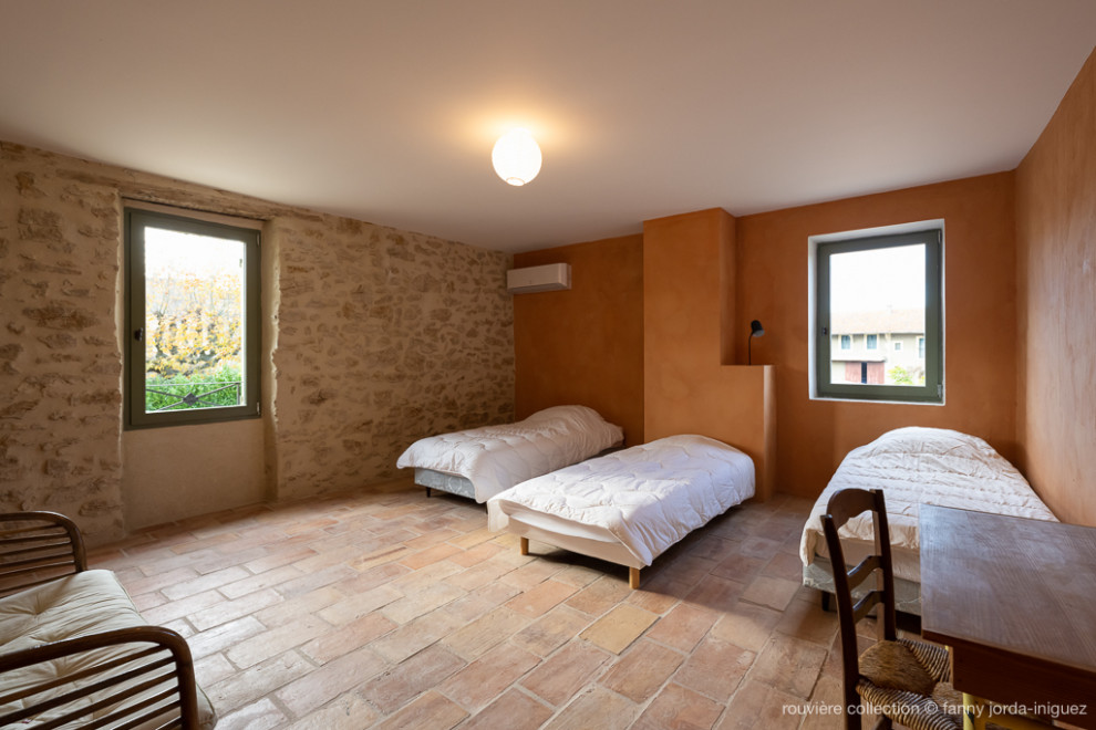 Imagen de dormitorio infantil bohemio grande con parades naranjas, suelo de baldosas de terracota y suelo marrón
