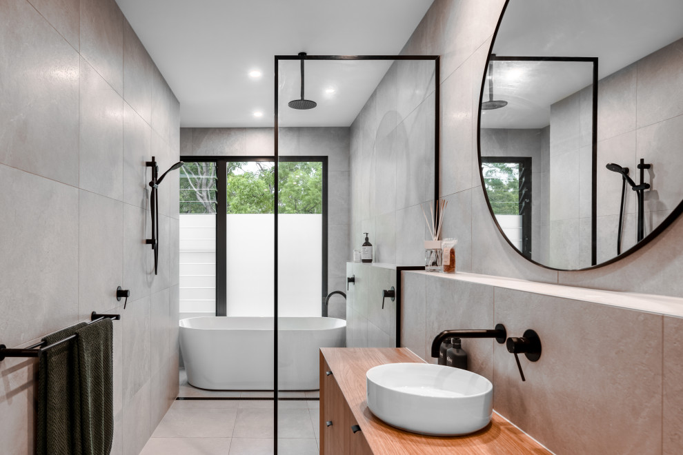 This is an example of a contemporary master wet room bathroom in Sunshine Coast with light wood cabinets, a freestanding tub, an open shower, grey benchtops and a built-in vanity.
