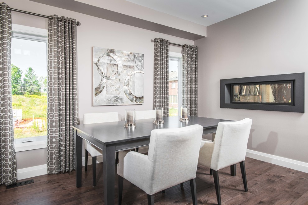 Photo of a transitional dining room in Toronto with grey walls, medium hardwood floors and a two-sided fireplace.