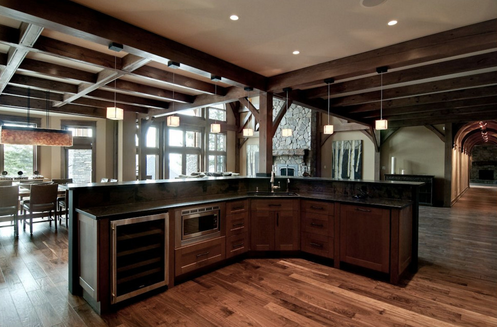 Example of a large mountain style medium tone wood floor open concept kitchen design in Boston with an undermount sink, shaker cabinets, dark wood cabinets, stainless steel appliances and an island