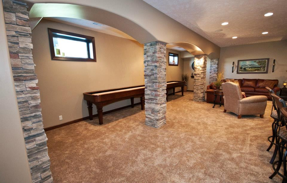Large transitional look-out basement in Omaha with beige walls, carpet and no fireplace.