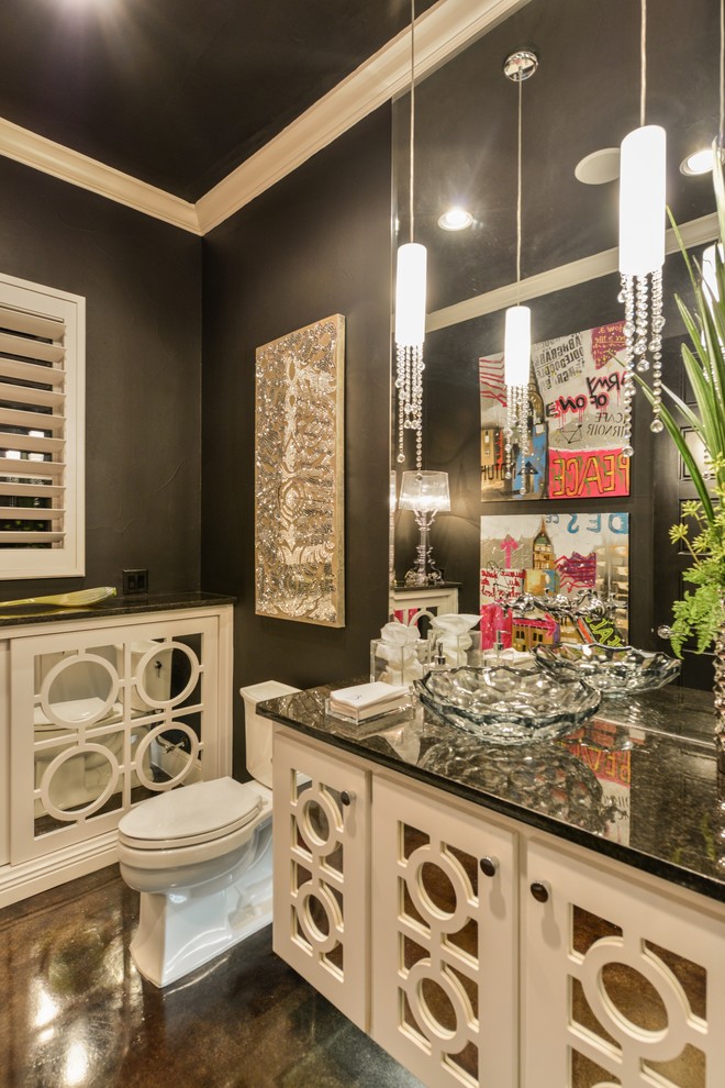 Traditional powder room in Austin with furniture-like cabinets, a two-piece toilet, black tile, black walls, concrete floors, a vessel sink, granite benchtops and beige cabinets.
