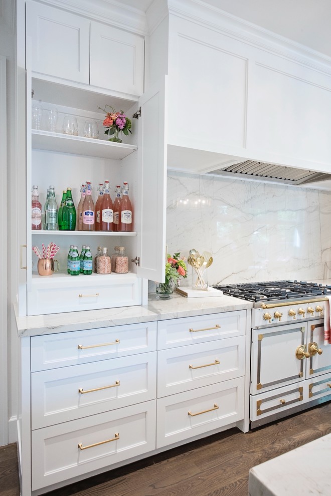Inspiration for a large transitional l-shaped medium tone wood floor and brown floor open concept kitchen remodel with a farmhouse sink, recessed-panel cabinets, white cabinets, quartzite countertops, white backsplash, stone slab backsplash, paneled appliances and an island