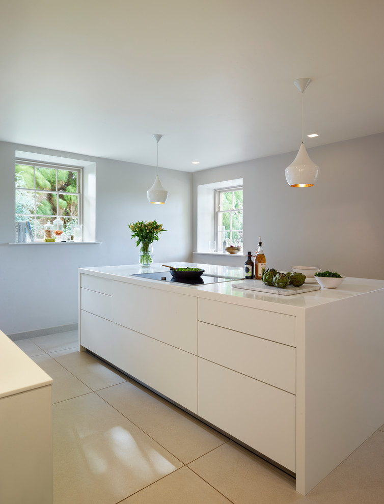 This is an example of a large contemporary galley eat-in kitchen in Other with an integrated sink, flat-panel cabinets, white cabinets, solid surface benchtops, stainless steel appliances, ceramic floors and with island.
