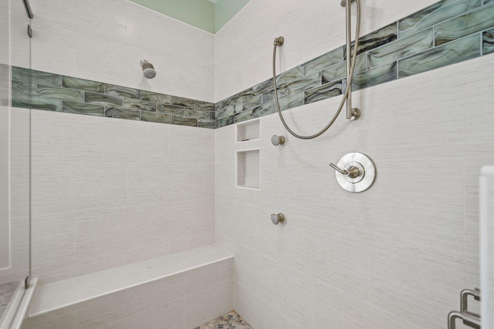 Réalisation d'une salle de bain principale marine avec une douche ouverte, un carrelage multicolore, un mur vert et un sol en galet.