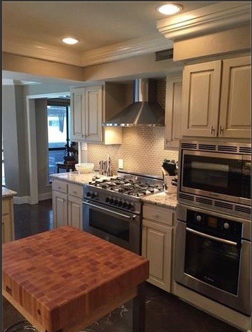Example of a mid-sized transitional marble floor enclosed kitchen design in Austin with a single-bowl sink, raised-panel cabinets, gray cabinets, granite countertops, gray backsplash, glass tile backsplash, stainless steel appliances and an island