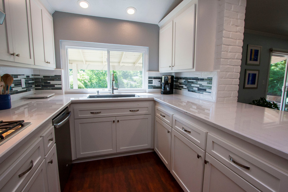 Example of a mid-sized transitional u-shaped dark wood floor eat-in kitchen design in Sacramento with an undermount sink, shaker cabinets, white cabinets, quartz countertops, multicolored backsplash, glass tile backsplash, colored appliances and a peninsula