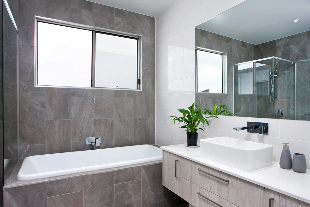 Inspiration for a mid-sized contemporary master bathroom in Sunshine Coast with flat-panel cabinets, light wood cabinets, a drop-in tub, a corner shower, gray tile, ceramic tile, a vessel sink and engineered quartz benchtops.