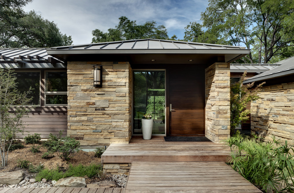 Inspiration for a contemporary exterior in Dallas with stone veneer and a metal roof.