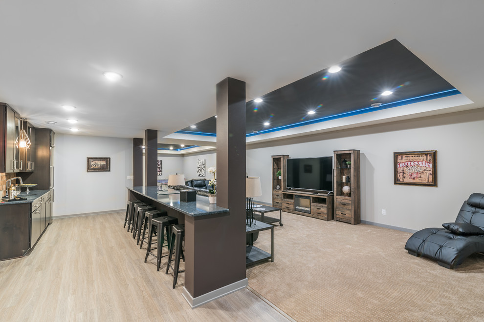 Large transitional fully buried basement in Milwaukee with grey walls, light hardwood floors, no fireplace and beige floor.