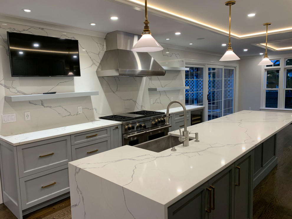 Inspiration for a large transitional galley separate kitchen in Boston with a farmhouse sink, raised-panel cabinets, quartzite benchtops, white splashback, stone slab splashback, stainless steel appliances, dark hardwood floors, with island, brown floor, white benchtop and grey cabinets.
