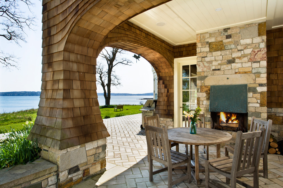 Design ideas for a beach style patio in Seattle with a fire feature, concrete pavers and a roof extension.