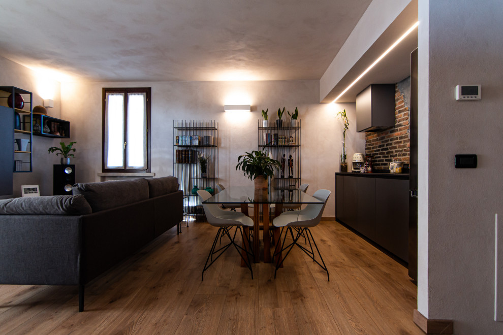 Great room - small industrial laminate floor and brick wall great room idea in Milan