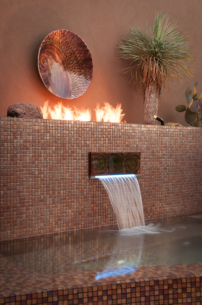 Inspiration for a large contemporary backyard custom-shaped infinity pool in Phoenix with a water feature and tile.
