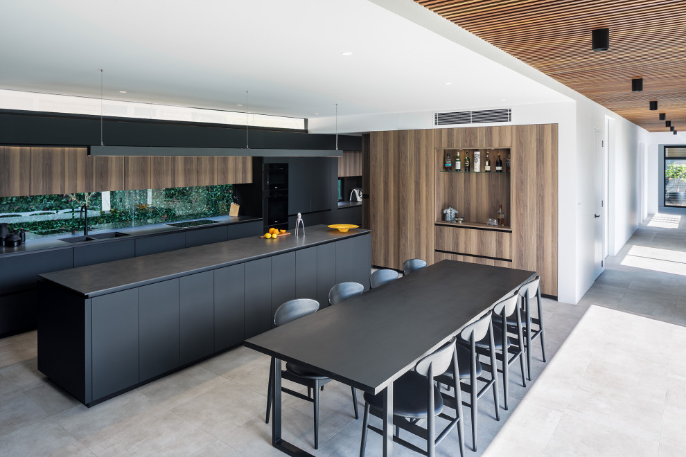 Inspiration for a modern l-shaped eat-in kitchen in Perth with a double-bowl sink, flat-panel cabinets, black cabinets, window splashback, with island, grey floor and black benchtop.