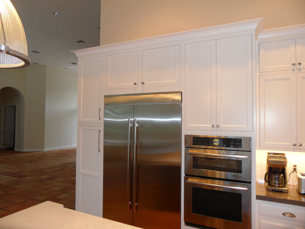 Large transitional l-shaped eat-in kitchen photo in Miami with an undermount sink, shaker cabinets, white cabinets, quartz countertops, white backsplash, ceramic backsplash, stainless steel appliances and an island