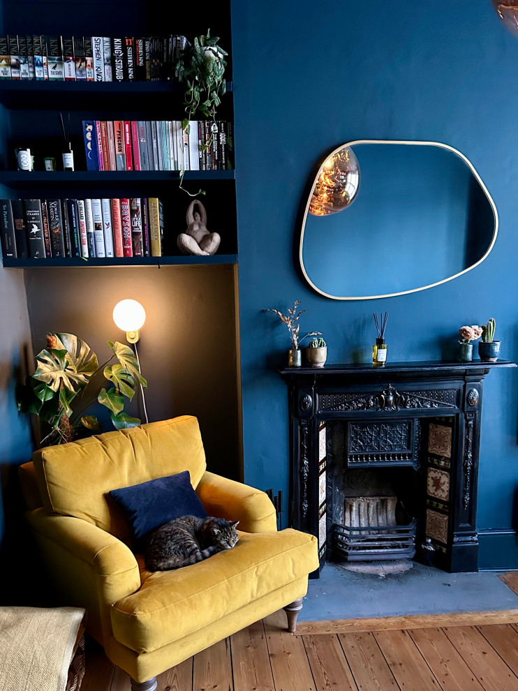 Mittelgroßes, Abgetrenntes Modernes Wohnzimmer mit blauer Wandfarbe, braunem Holzboden, Kamin, Kaminumrandung aus Metall, TV-Wand und braunem Boden in London